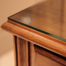 Plateau de table en verre posé sur un meuble en bois.